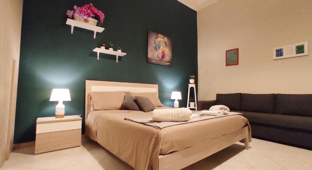 a bedroom with a bed and a couch at Apartment's - 500 mt Pompeii Ruins-Vesuvio in Pompei