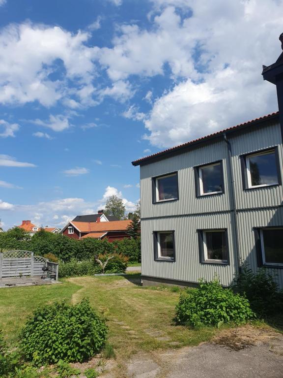 een wit huis met ramen naast een tuin bij B&F Lägenheter in Nora