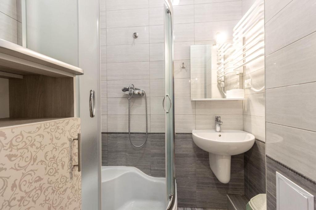 La salle de bains est pourvue d'une douche, d'un lavabo et de toilettes. dans l'établissement Apartment Ryadom S Ploshadiu Rynok, à Lviv