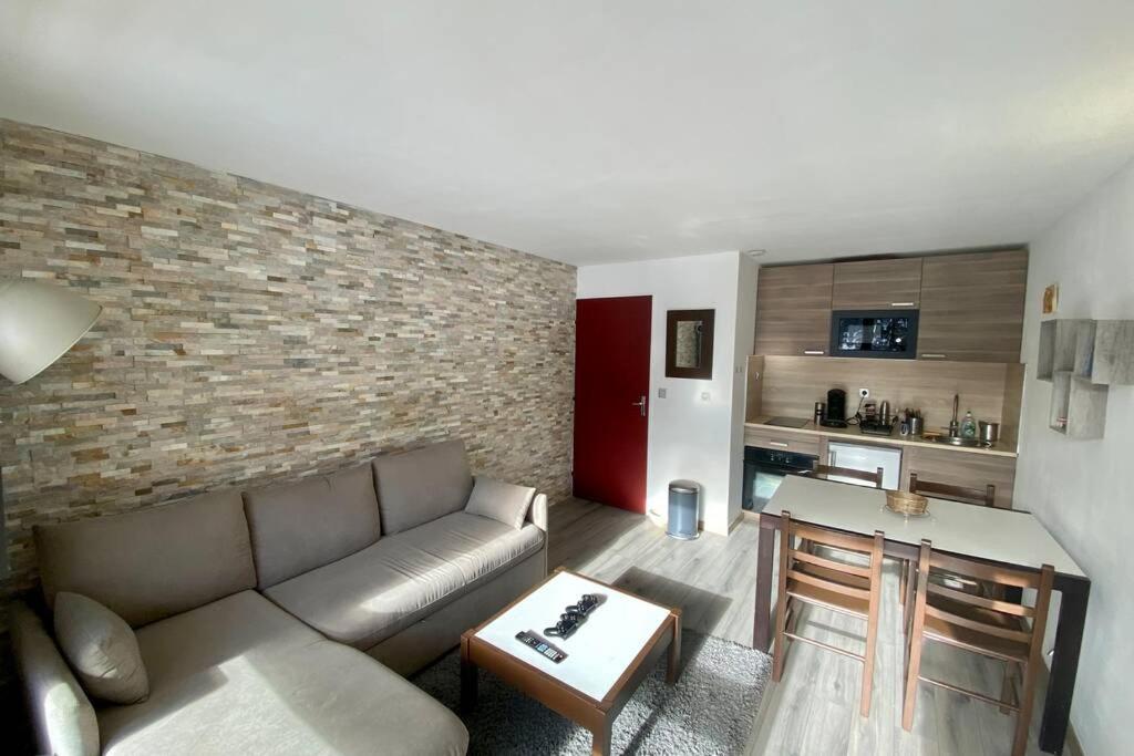 uma sala de estar com um sofá e uma mesa em Appartement chaleureux - pied des pistes em Corrençon-en-Vercors