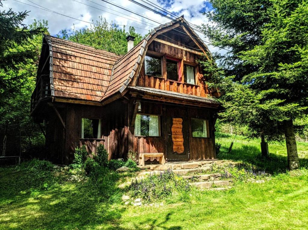 una vecchia casa in legno in mezzo a un campo di Bajeczka a Dwernik