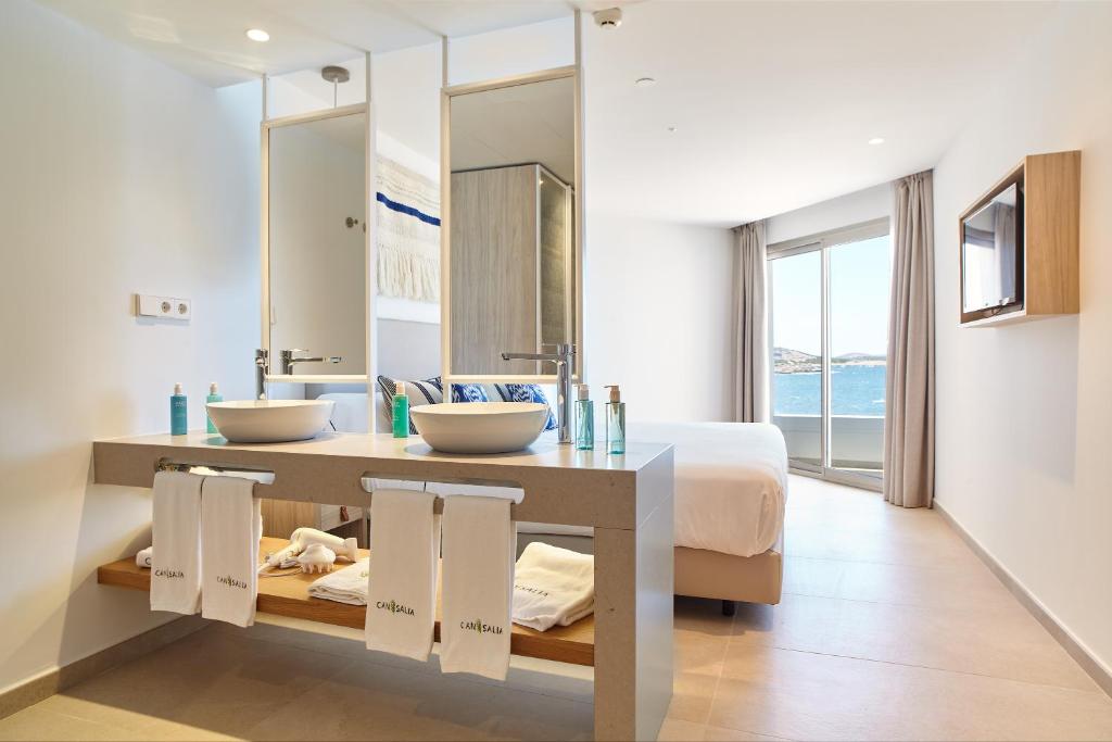 a bathroom with two sinks and a large mirror at Can Salia in San Antonio Bay