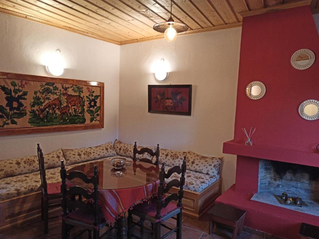 a dining room with a table and a couch at ELLI΄S HOUSE ΣΥΓΧΡΟΝΟ ΣΠΙΤΙ ΣΤΑ ΠΡΑΜΑΝΤΑ in Pramanta