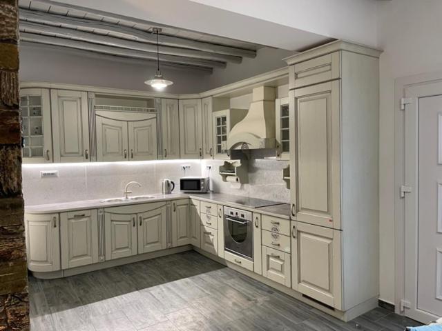 a large kitchen with white cabinets and a sink at "Stalia" beach house in Vári