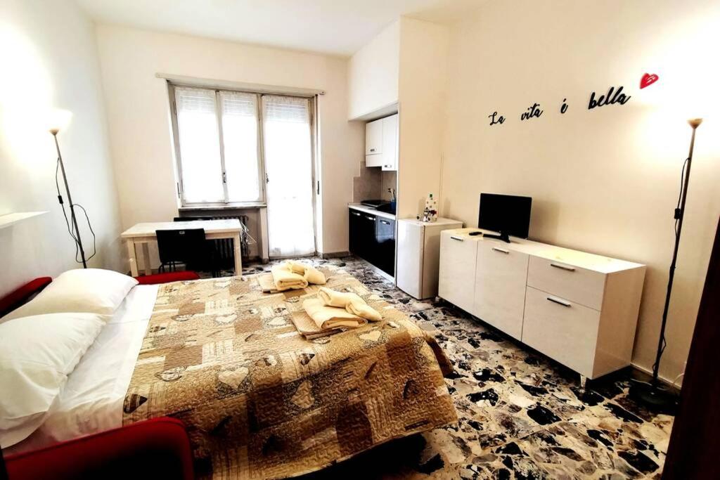 a bedroom with a large bed and a kitchen at Locazione Turistica La Primula in Turin