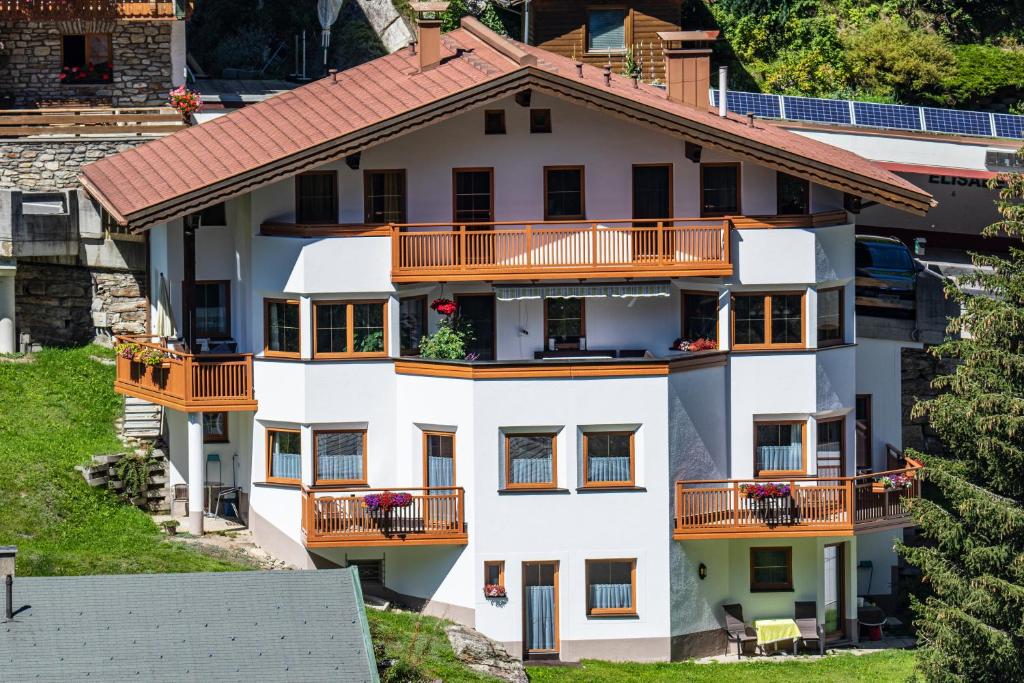 een luchtzicht op een wit huis met oranje balkons bij Haus Markus Strolz in Sankt Anton am Arlberg