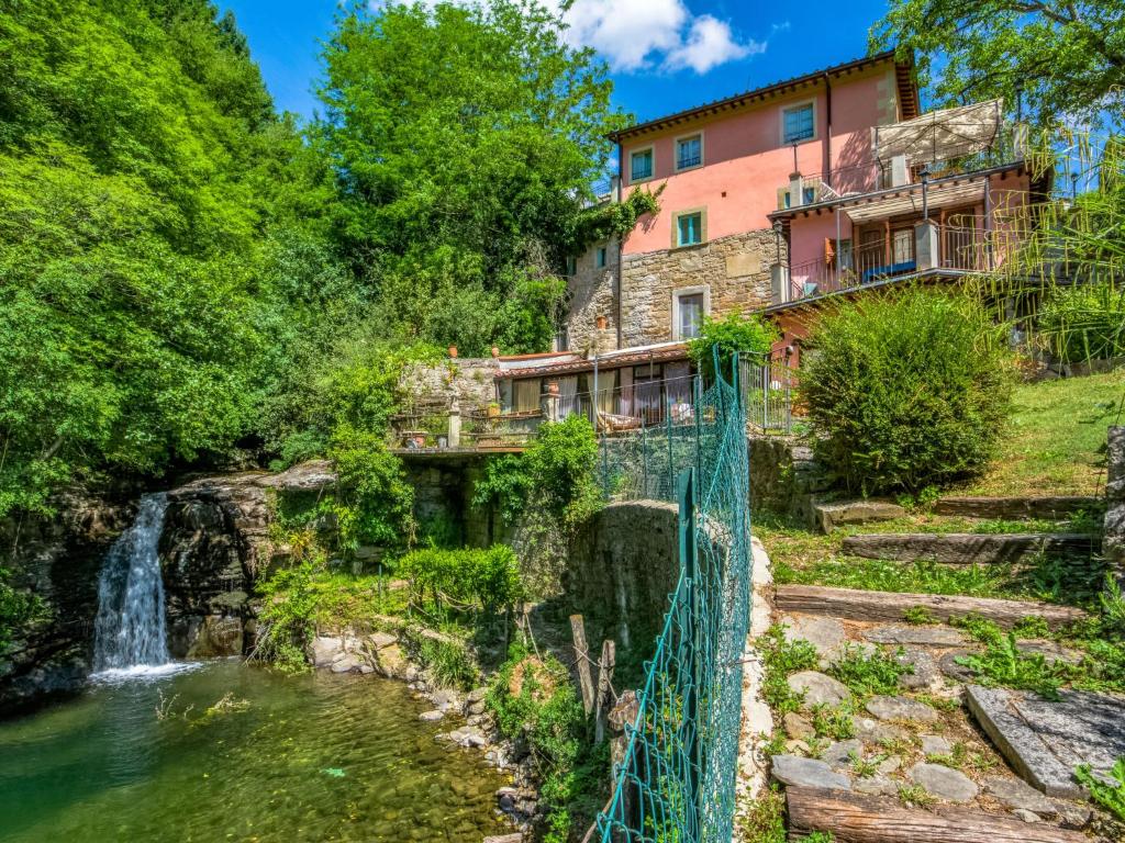 a house with a waterfall and a bridge over a pond at Apartment Rosa by Interhome in Il Molinaccio