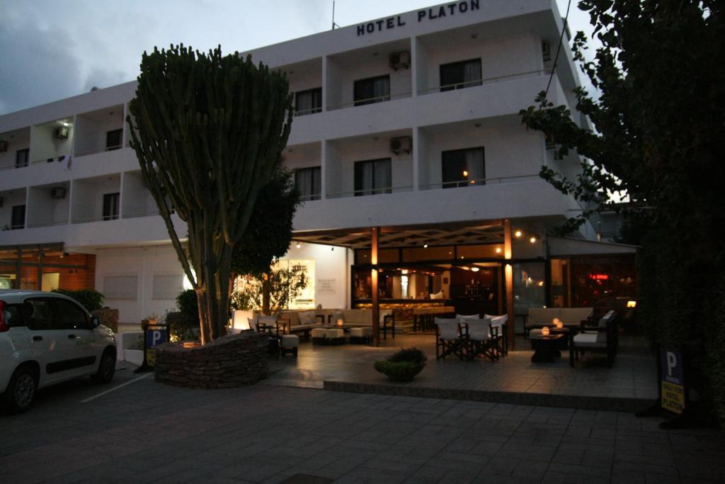 a hotel with a parking lot in front of it at Hotel Platon in Faliraki