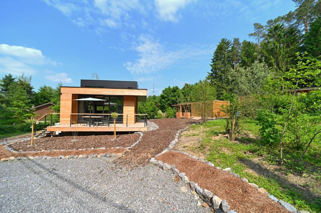 a house in the woods with a gravel driveway at Wild Cube in Durbuy