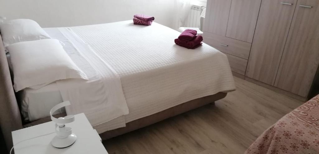a bedroom with a bed with white sheets and purple pillows at Casa Marina in Foligno