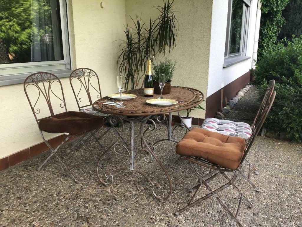 a table with two chairs and a bottle of wine at Ferienwohnung Panoramablick in Rimbach