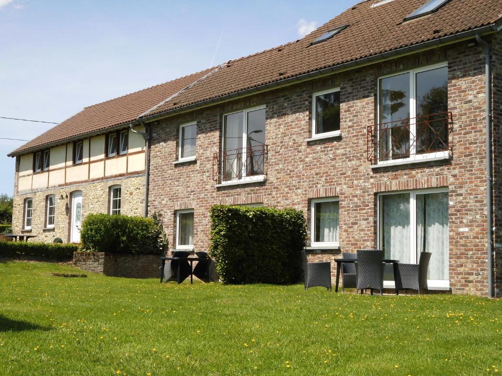 a brick building with windows and chairs in the yard at 't Gulpdal Hotel Voeren-Teuven in Voeren