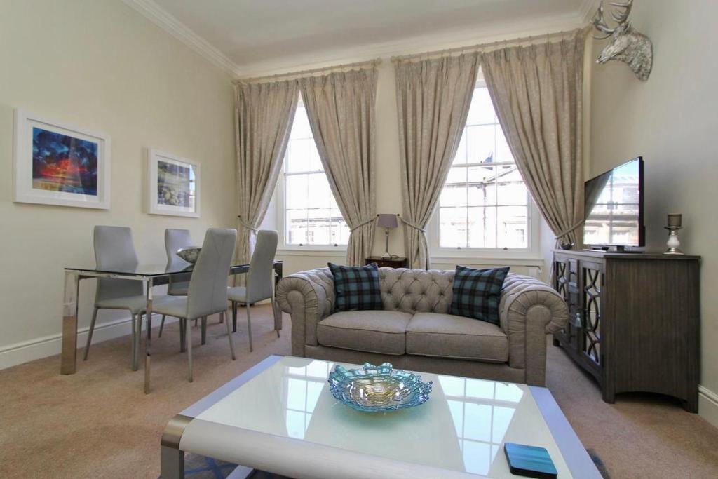 a living room with a couch and a table at Escape To Edinburgh @ Broughton Place in Edinburgh