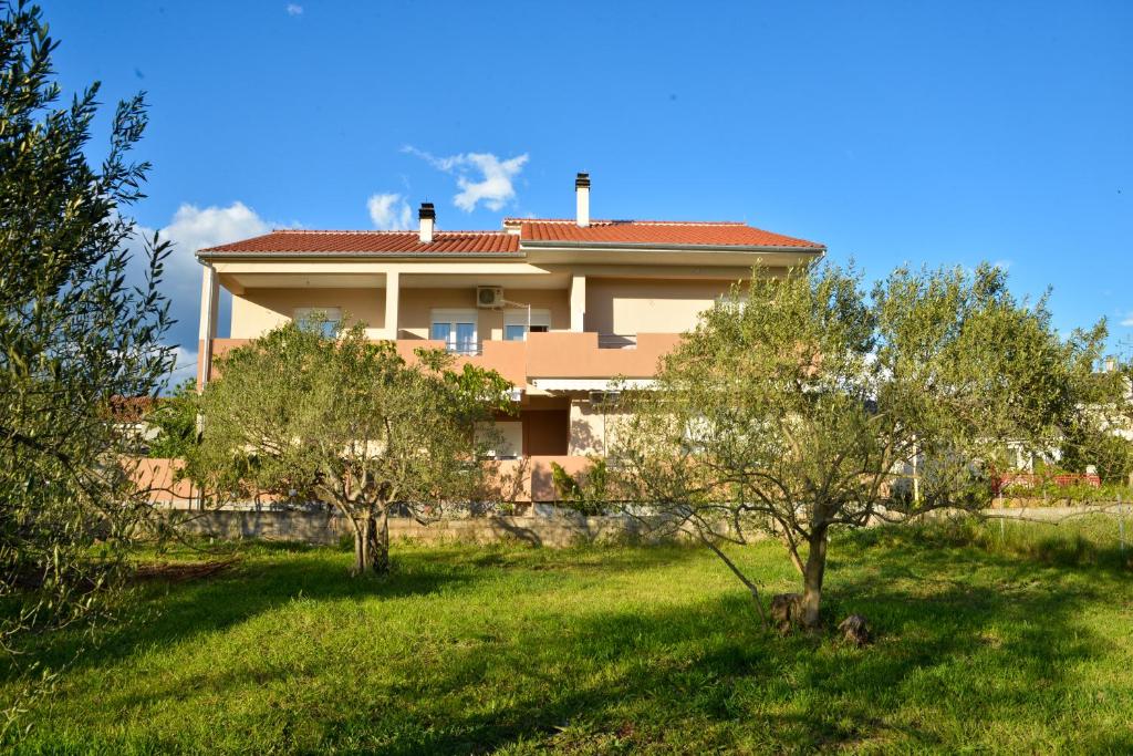 a house with a yard with trees in front of it at Apartments Anita in Bibinje