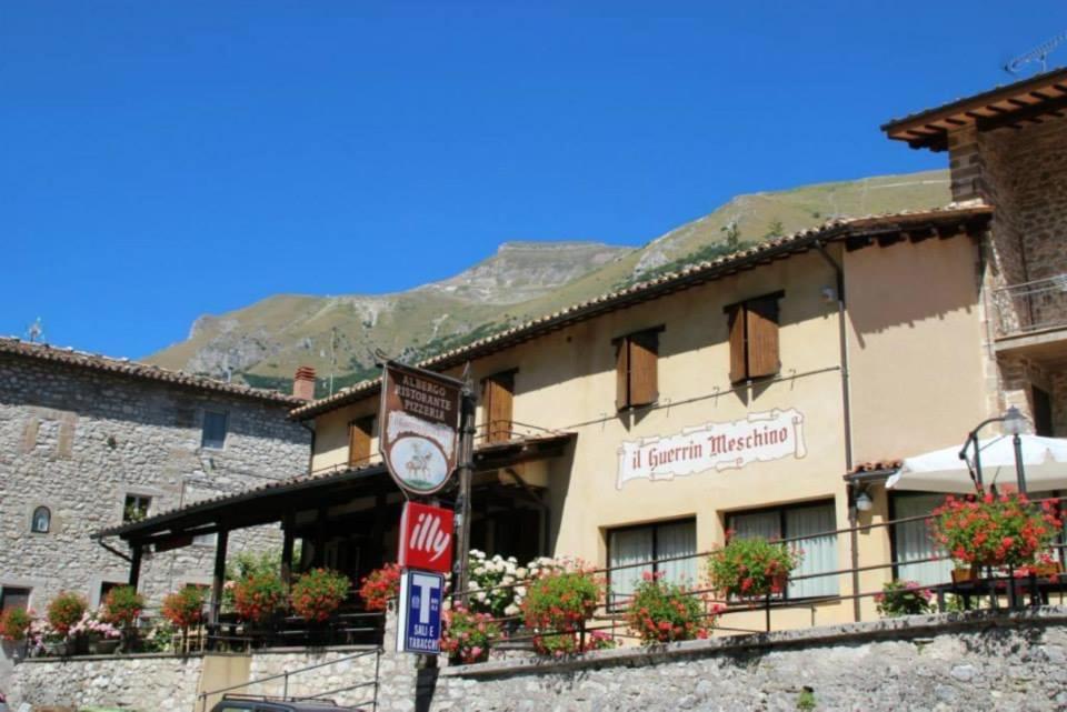 un hôtel avec une horloge devant un bâtiment dans l'établissement Guerrin Meschino, à Montemonaco