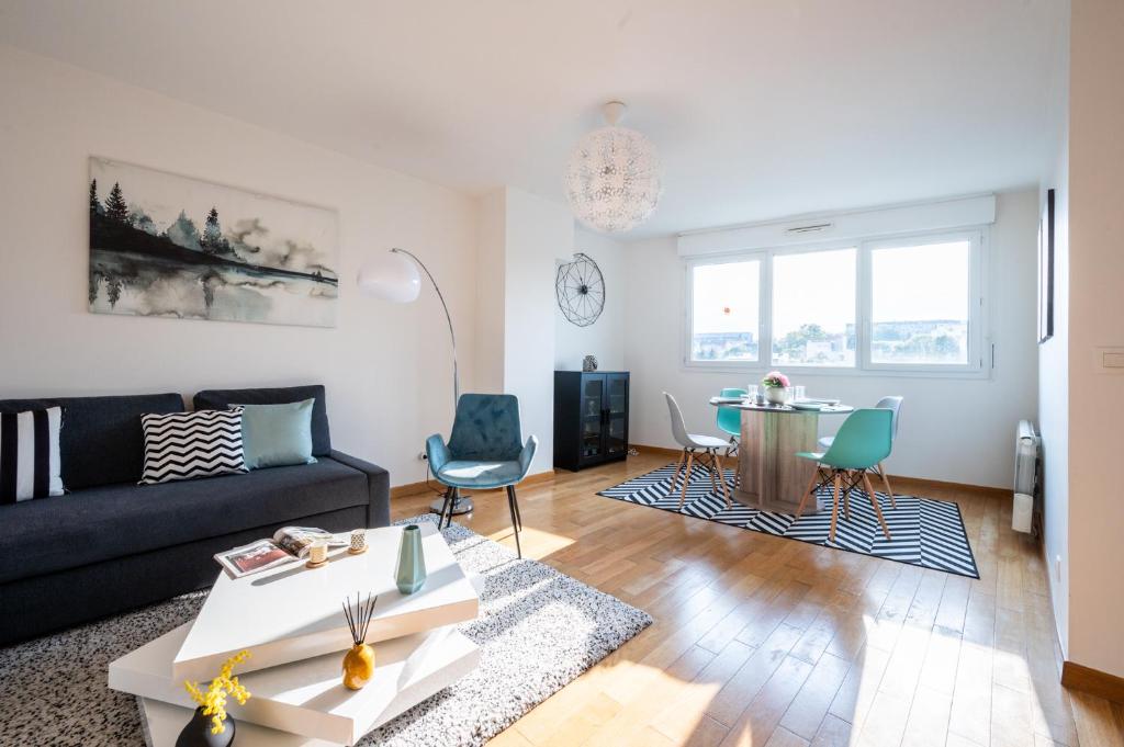 ein Wohnzimmer mit einem Sofa und einem Tisch in der Unterkunft Immotovo - Suite moderne - Paris 8 min - Parking - NETFLIX in Villejuif