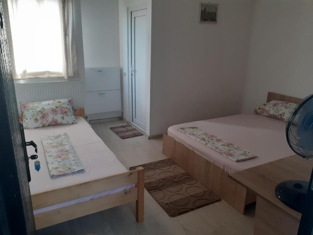 a small room with two beds and a window at Kociu's House in Constanţa