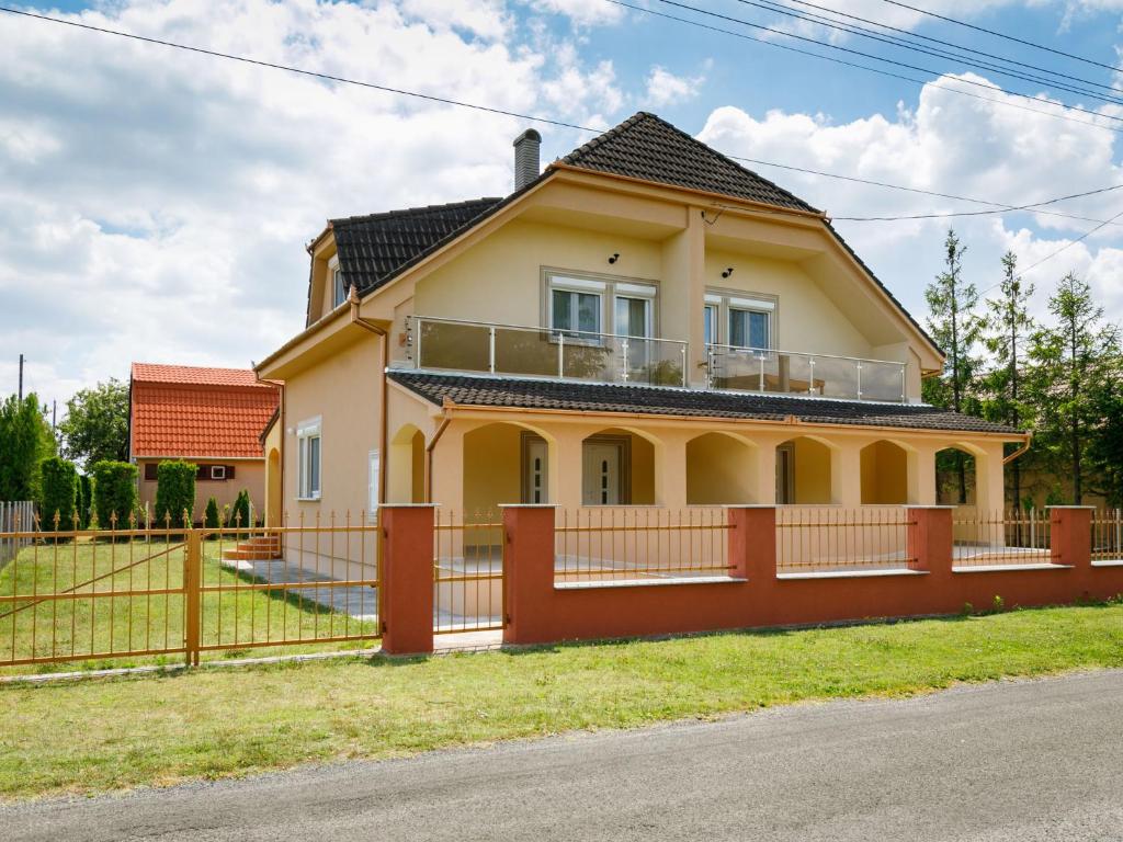 uma casa amarela com uma cerca em frente em Holiday Home Daisy 1 by Interhome em Balatonmáriafürdő