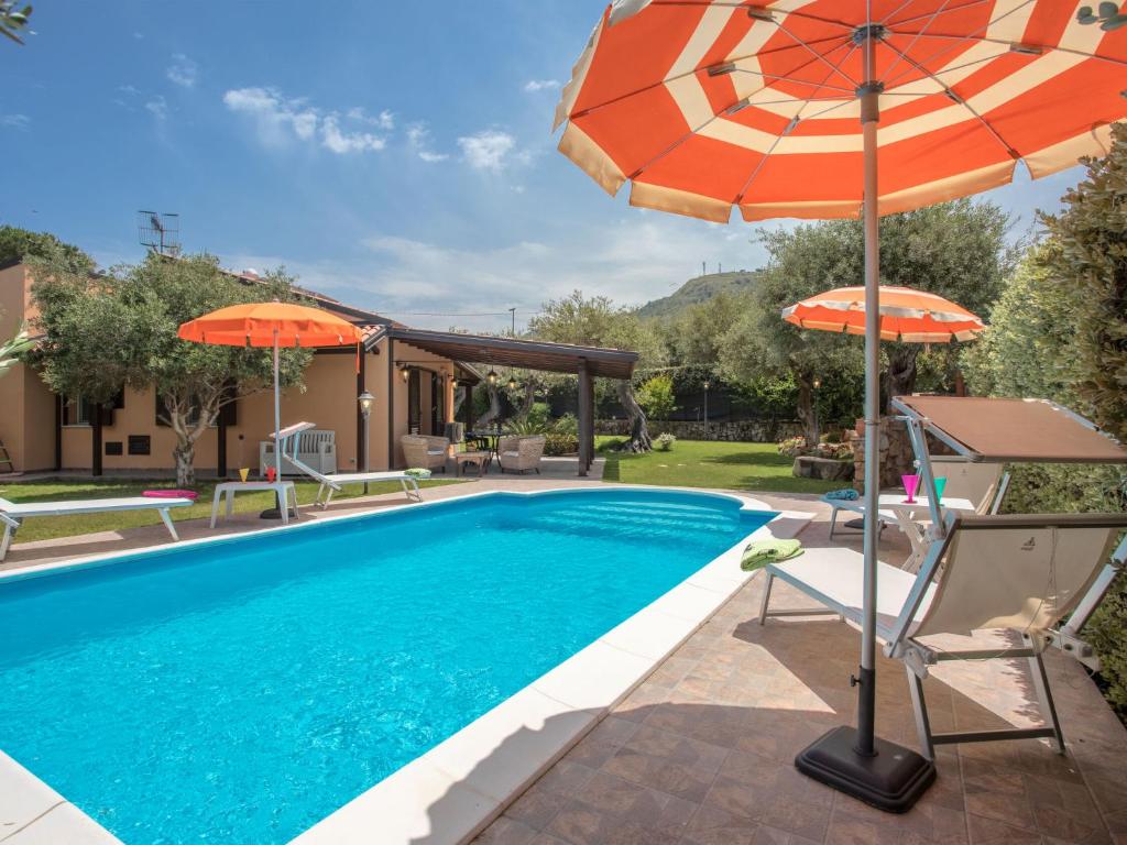 una piscina con sombrilla naranja, sillas y sombrillas en Villa Jancaliva by Interhome en Lascari