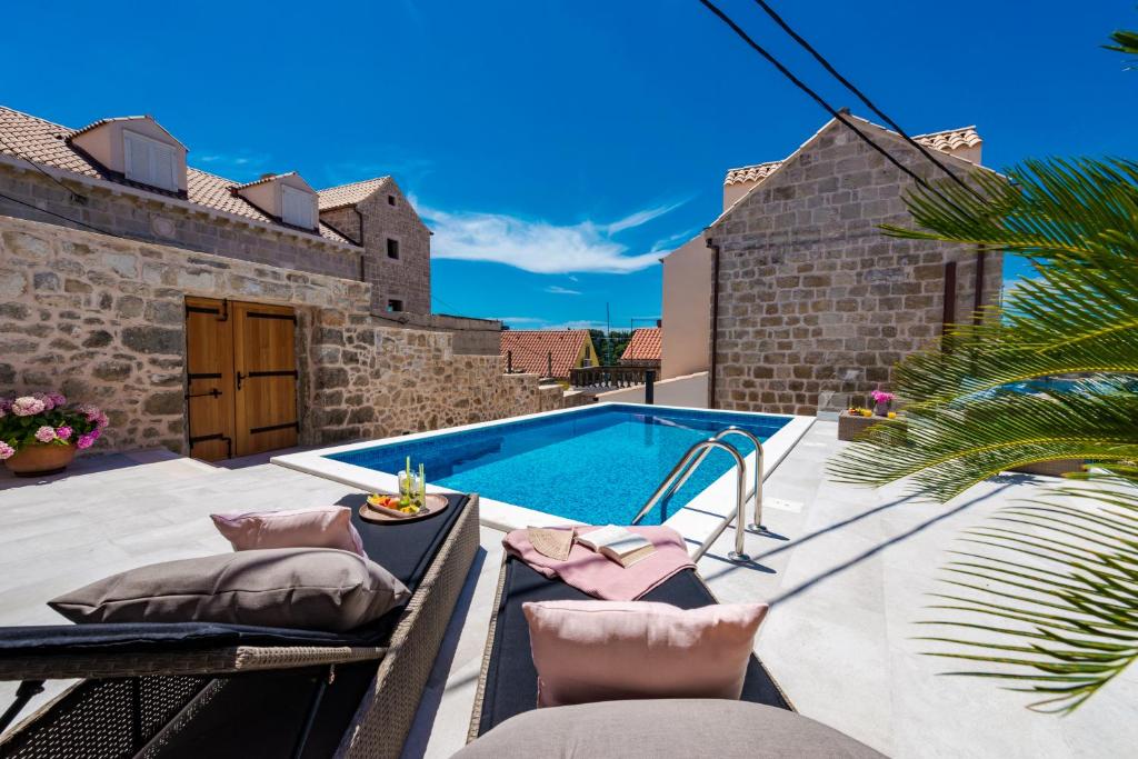 a patio with a swimming pool and a villa at Villa Luigi with a pool in Cavtat