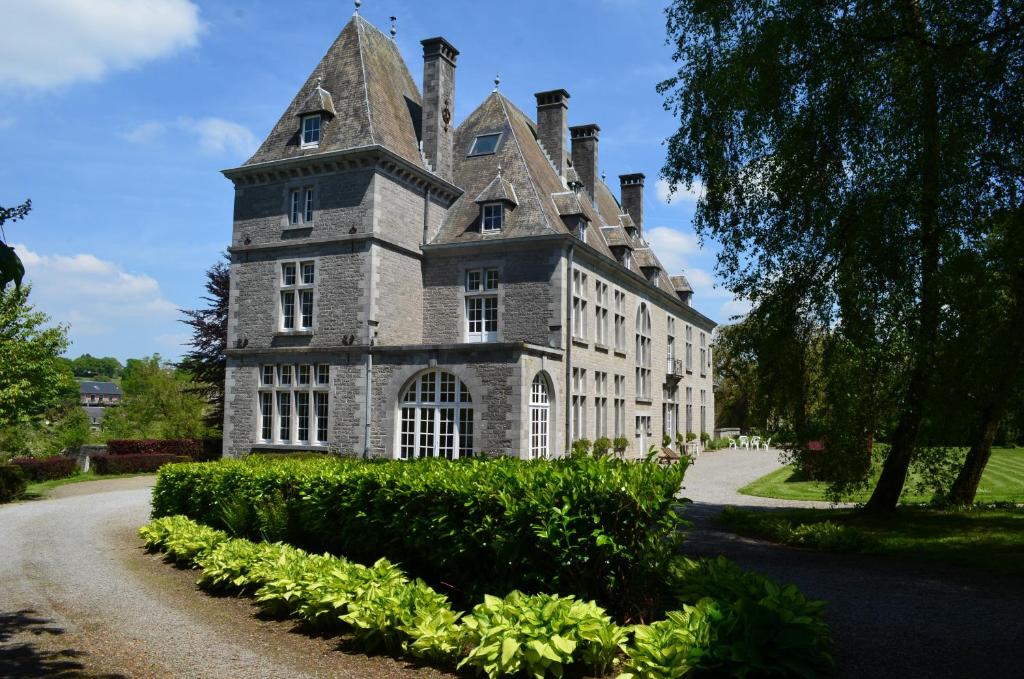 an old stone house with a tower on a road at Château de la Motte in Yvoir