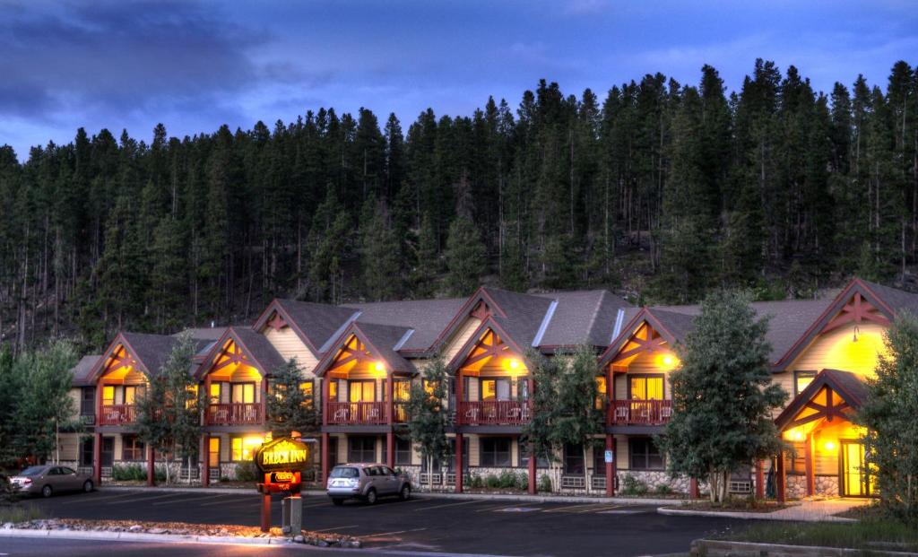 a large lodge with cars parked in a parking lot at Breck Inn in Breckenridge