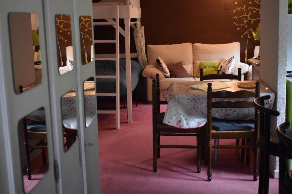 Cette chambre dispose d'une table, de chaises et de lits superposés. dans l'établissement Les Locations de Stéphanie Les Hautes Vosges, à Sondernach