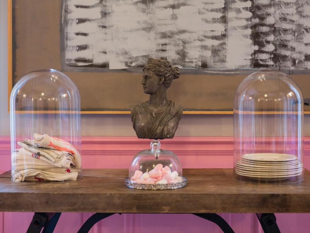 Un buste d&#39;une femme dans des dômes de verre sur une table dans l&#39;établissement Hôtel La Suite, à Villeneuve-lès-Avignon