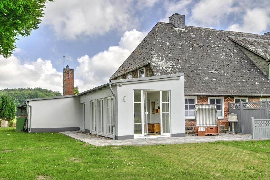 une maison blanche avec un toit gris dans l'établissement fewo1846 - Landliebe - idyllisch gelegene Wohnung mit 2 Schlafzimmern und Garten, à Husby