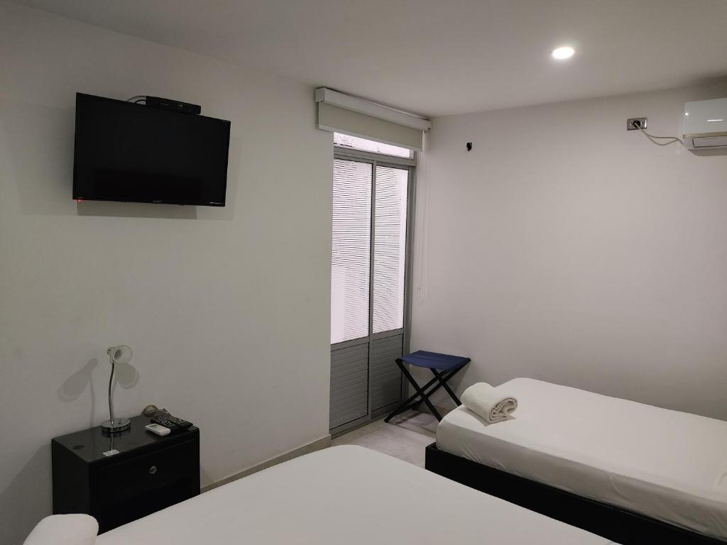 Postel nebo postele na pokoji v ubytování HOTEL ESCALA GC Valledupar