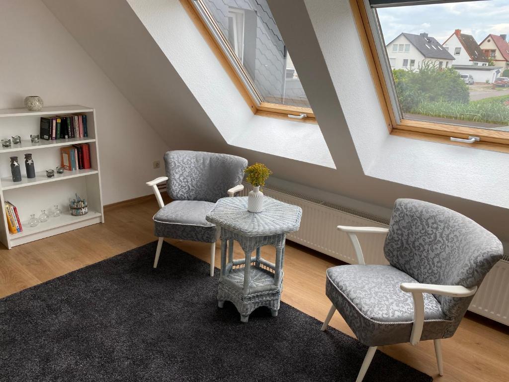 a attic room with two chairs and a table and a window at Henning 2 in Kirchdorf