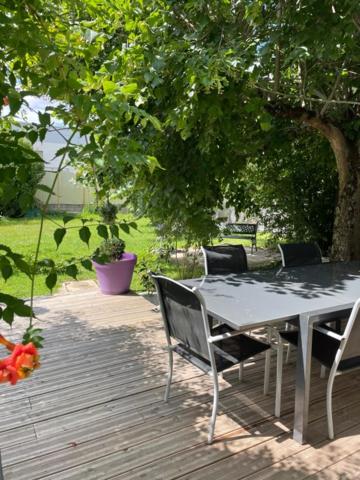 une table et des chaises assises sous un arbre dans l'établissement Maison 4 chambres jardin et parking, à Déols