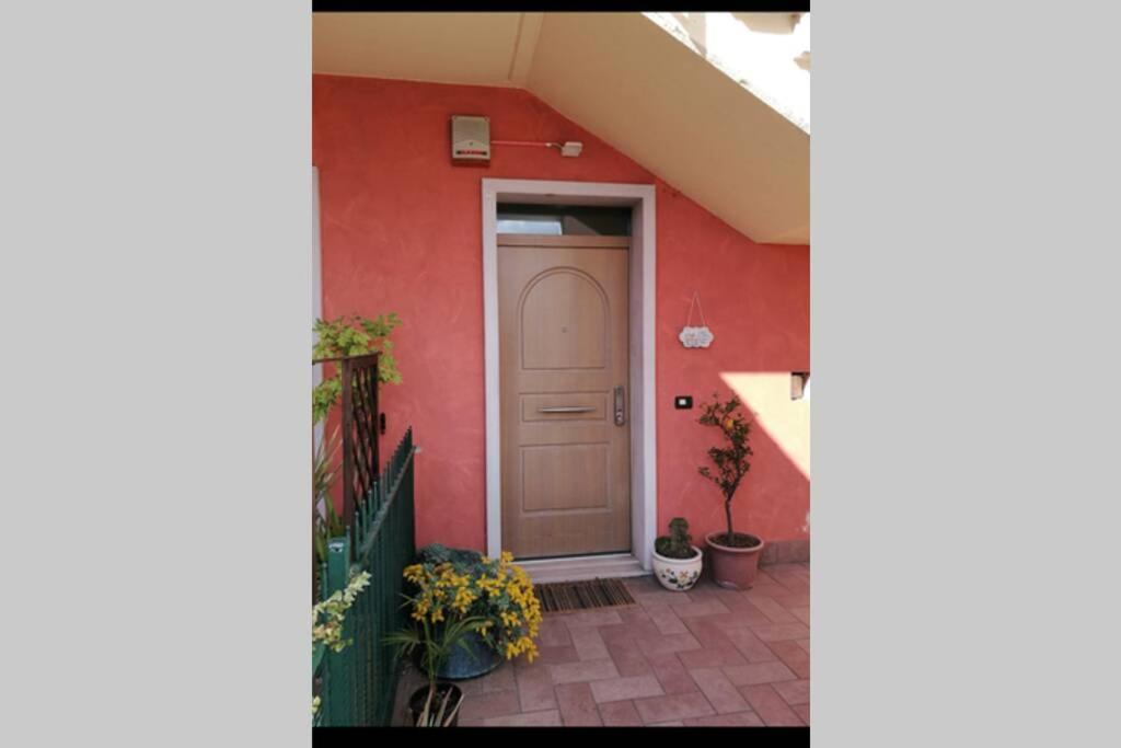uma porta para uma casa com uma parede vermelha em La Casetta, appartamento nel verde a Sommacampagna em Sommacampagna