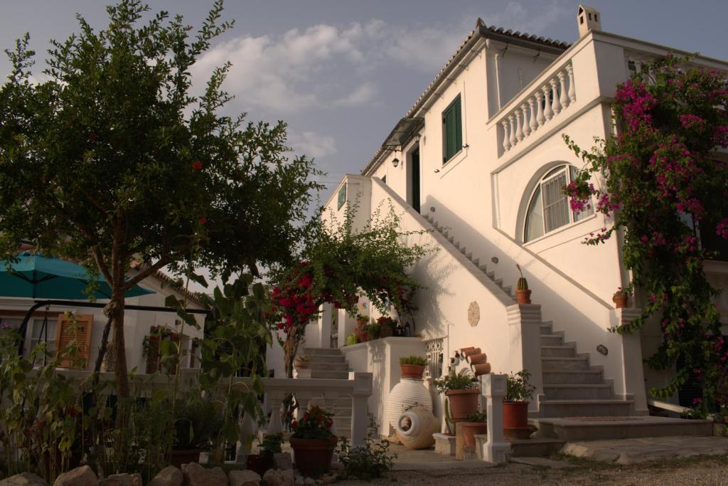 Casa blanca con escaleras, árboles y flores en Condillia II, en Spetses