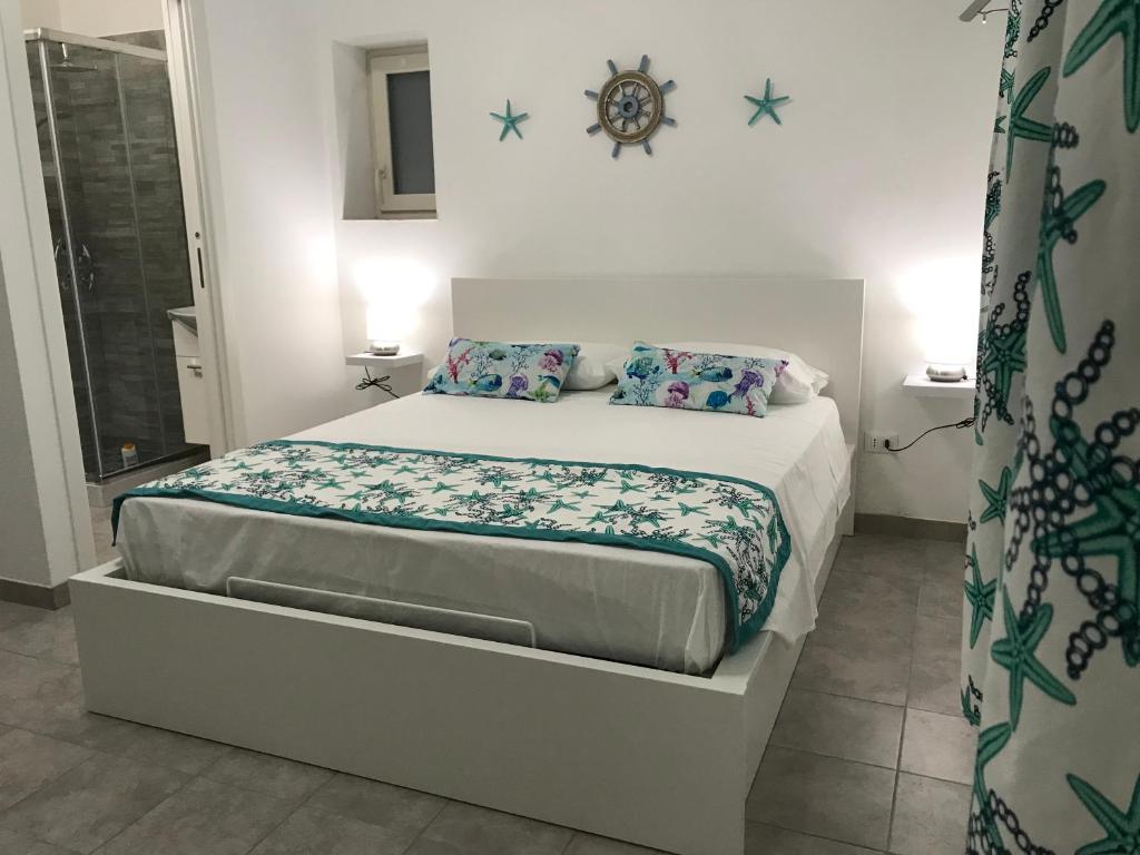 Monolocale Stella Marina في بورتو بالو: غرفة نوم بسرير في غرفة بيضاء