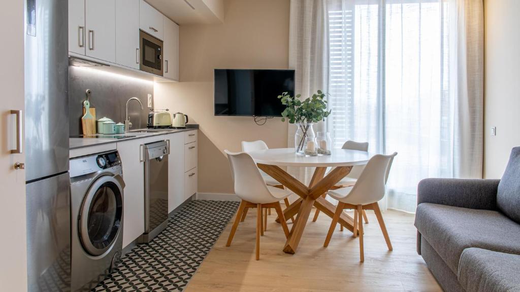 a kitchen and living room with a table and a washing machine at BARCELONA TOUCH APARTMENTS - Progres in Hospitalet de Llobregat