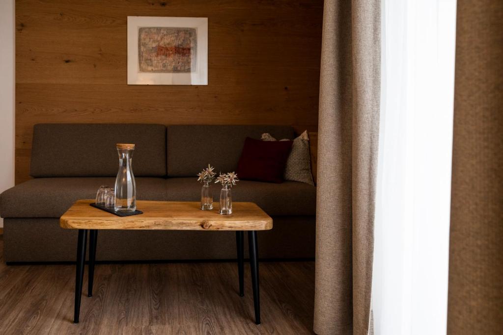 a table with a vase on it next to a couch at Hotel Montfort in Sankt Anton am Arlberg