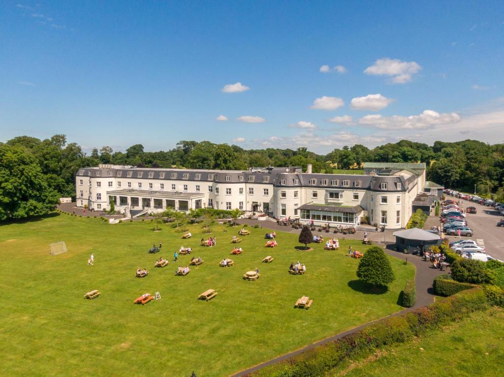 a group of cows laying on a field in front of a building at Bloomfield House Hotel, Leisure Club & Spa in Mullingar
