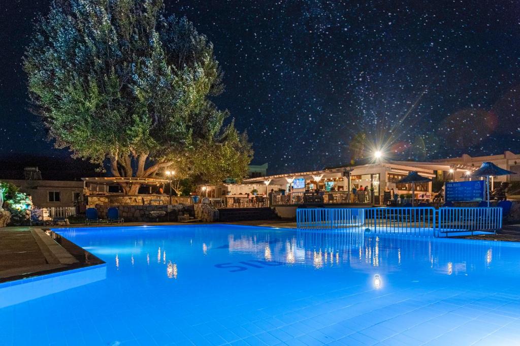 una piscina notturna con cielo stellato di Gelli Apartments a Città di Kos