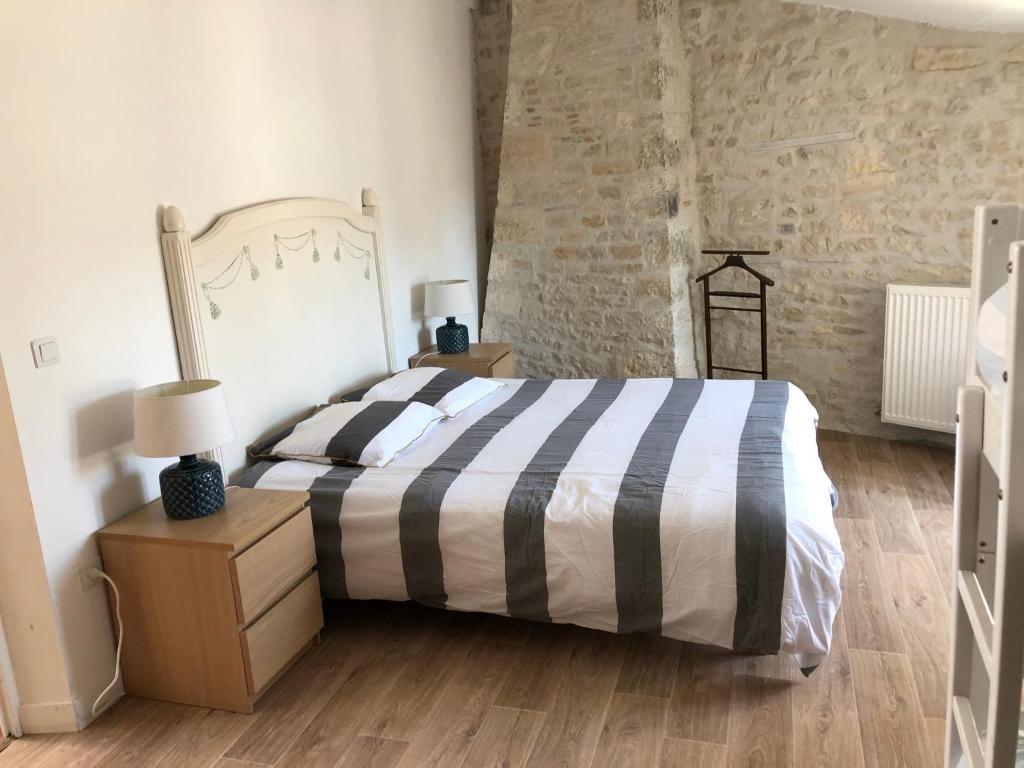 um quarto com uma cama e uma parede de tijolos em Maison de charme LA ROCHELLE ILE DE RE em Dompierre-sur-Mer