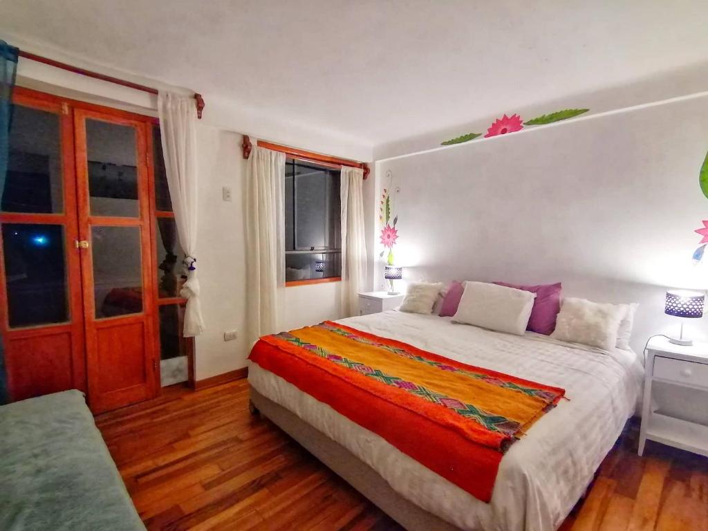 - une chambre avec un grand lit et une fenêtre dans l'établissement Hostal Chaska Wasi, à Ollantaytambo