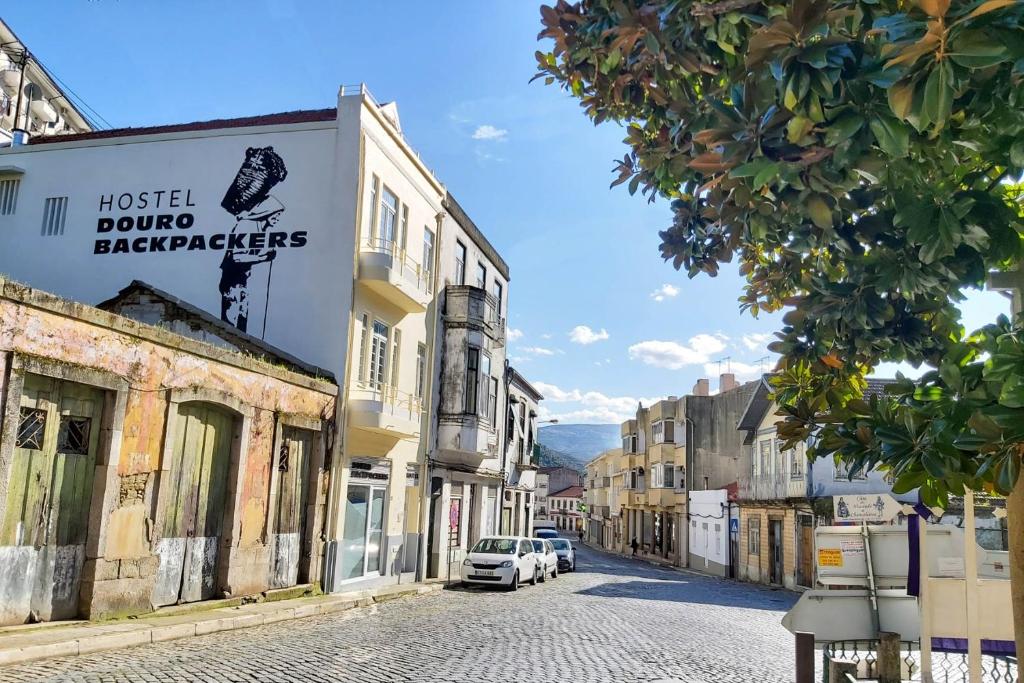 Una calle de una ciudad con coches aparcados en la carretera. en Hostel Douro Backpackers, en Pinhão