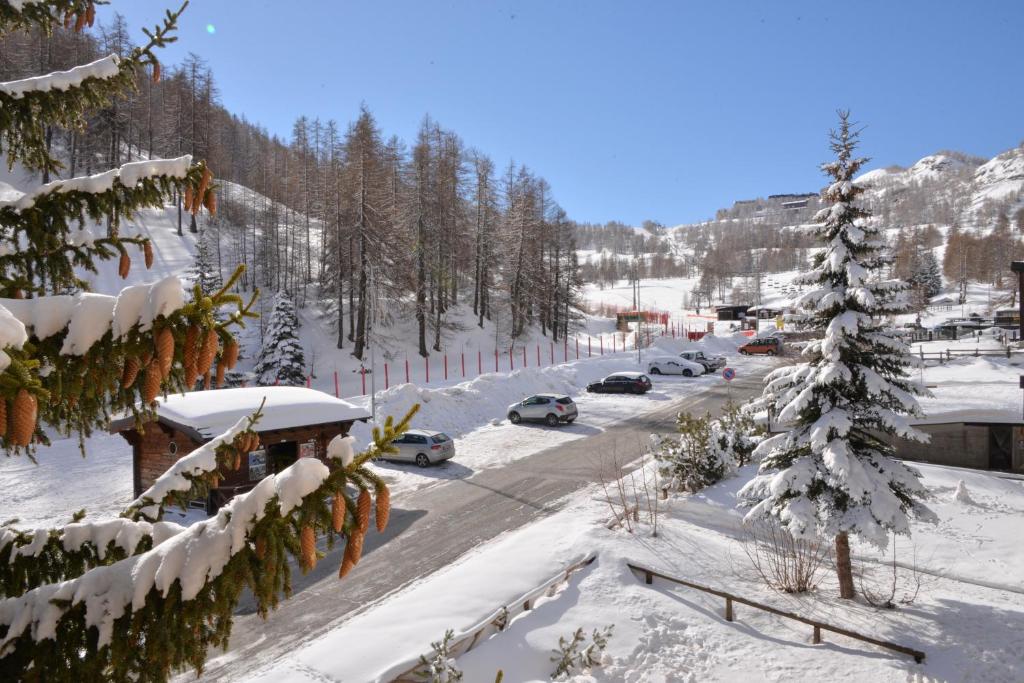 a snow covered street with cars driving down a road at House La Motta by Holiday World in Borgata Sestriere