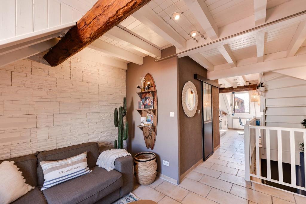 un salon avec un canapé et un mur de briques dans l'établissement Carnot on the Roof 2 - 4 personnes Lac at 400m, à Annecy