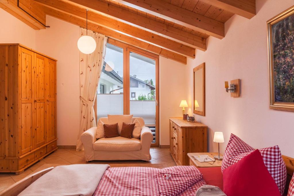 uma sala de estar com um sofá e uma cadeira em Das Bergzeit em Farchant