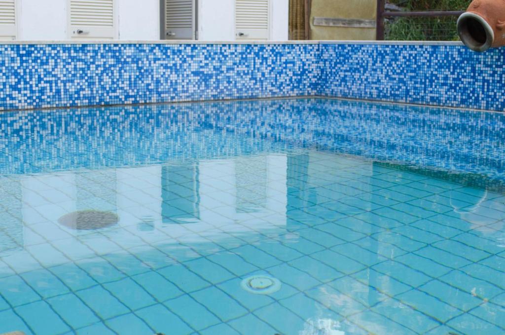 a swimming pool with blue walls and blue tiles at Hotel Angelino in Ischia