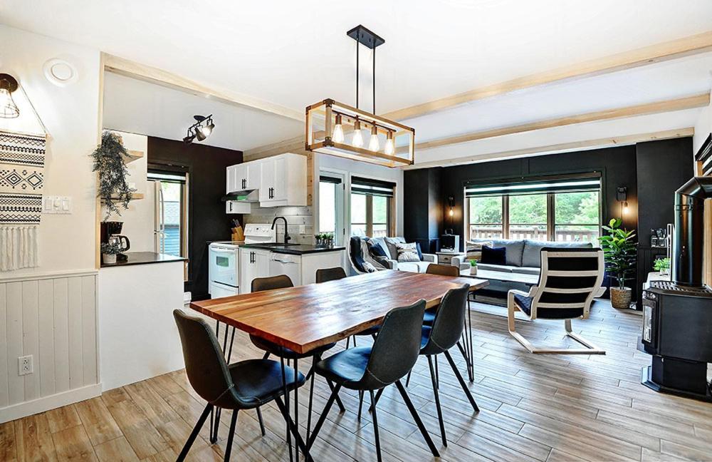 cocina y sala de estar con mesa de madera y sillas en Chalets Alpins -09 Chemin Alpin, en Stoneham