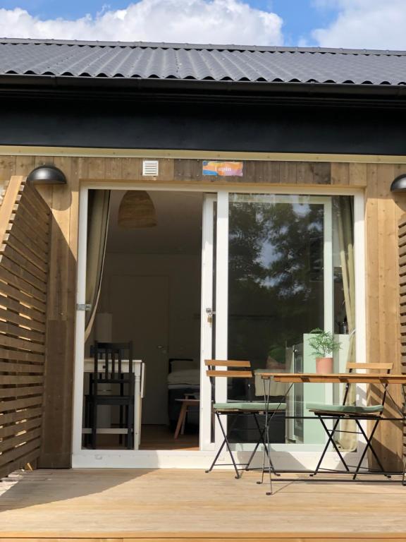 patio con tavolo e sedie sotto il portico di Kaggeholms strandboende a Ekerö