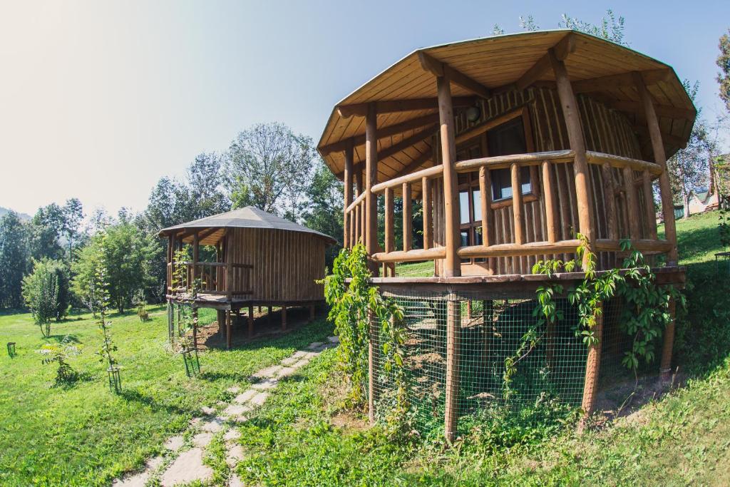 a wooden building with a gazebo in a field at Biliy Bizon in Luka