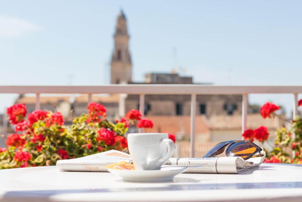 a table with a cup of coffee and a newspaper at And So in Lecce